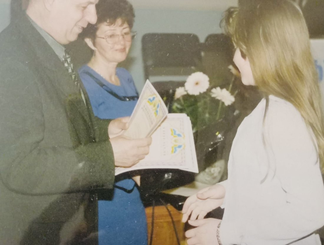 Olena receiving a certificate at a regional art prize-giving